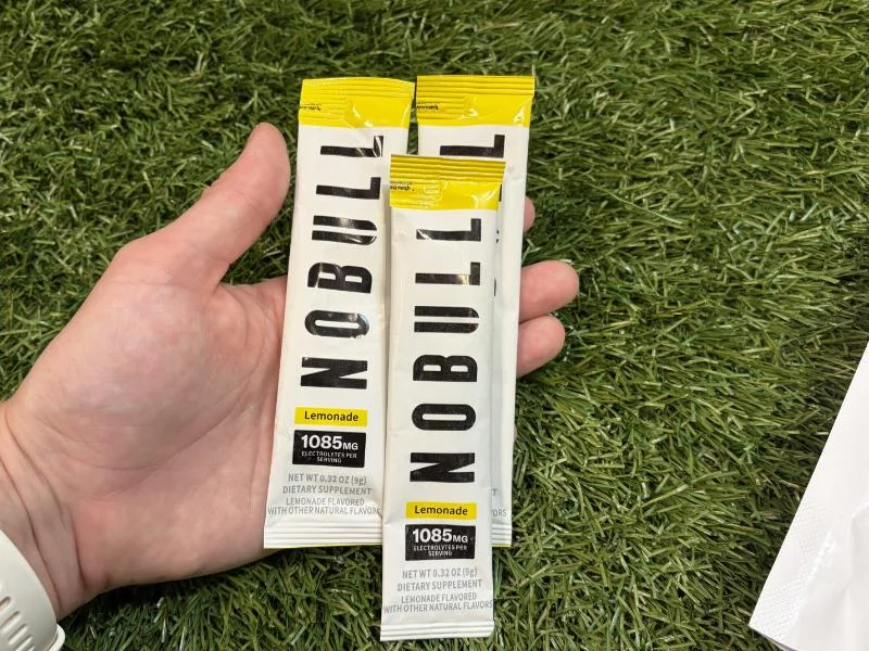 A hand holding individual sticks of NOBULL Electrolytes