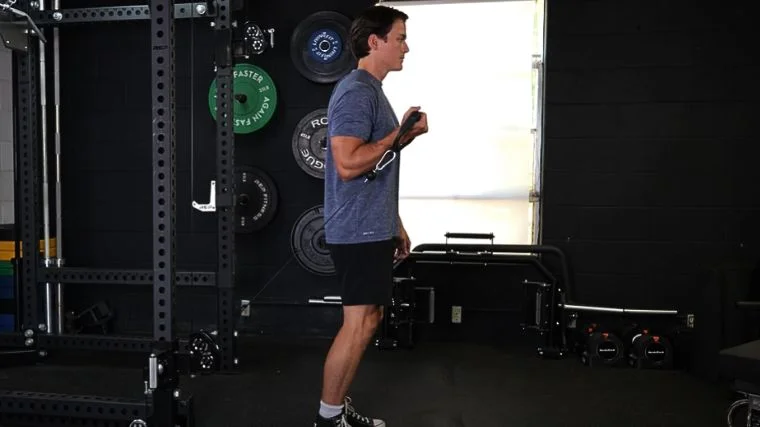 A person performing the bayesian cable curl.