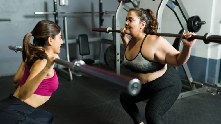 Two persons lifting weights in the gym