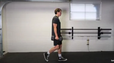 A person performing the farmer's carry exercise.