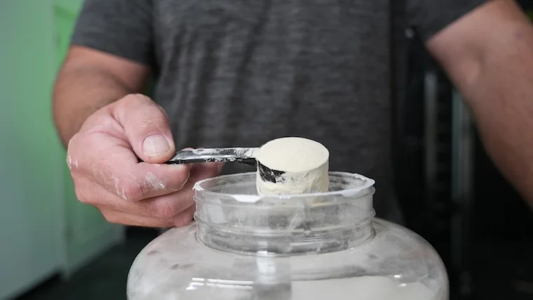 Our tester grabbing a single scoop of Naked Whey Protein