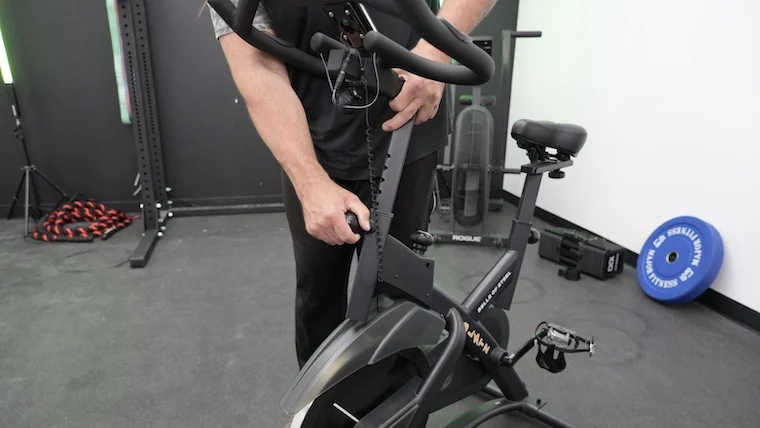 Our tester adjusts the Bells of Steel Indoor Cycling Bike.