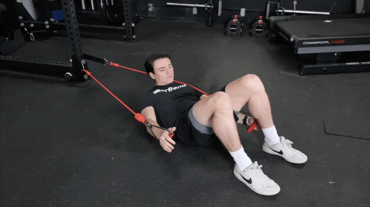 A person doing heel touches with resistance bands.