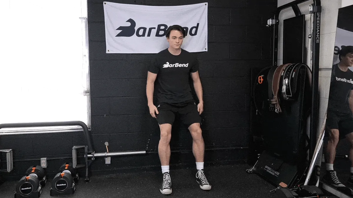 Jake performing the wall sit exercise in the BarBend gym.