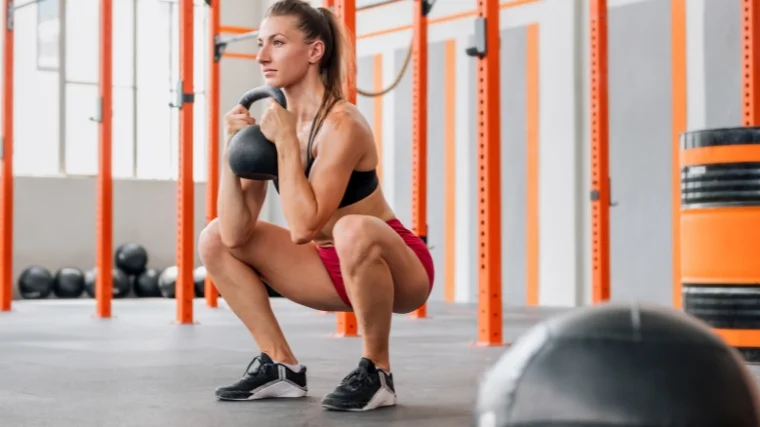A person doing a kettlebell squat.