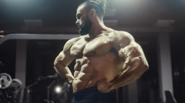 A bodybuilder showing his belly in the gym.