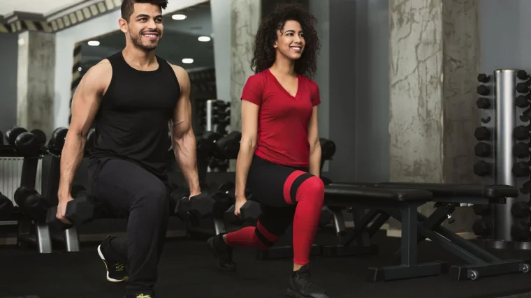 A couple of people doing dumbbell split squats.