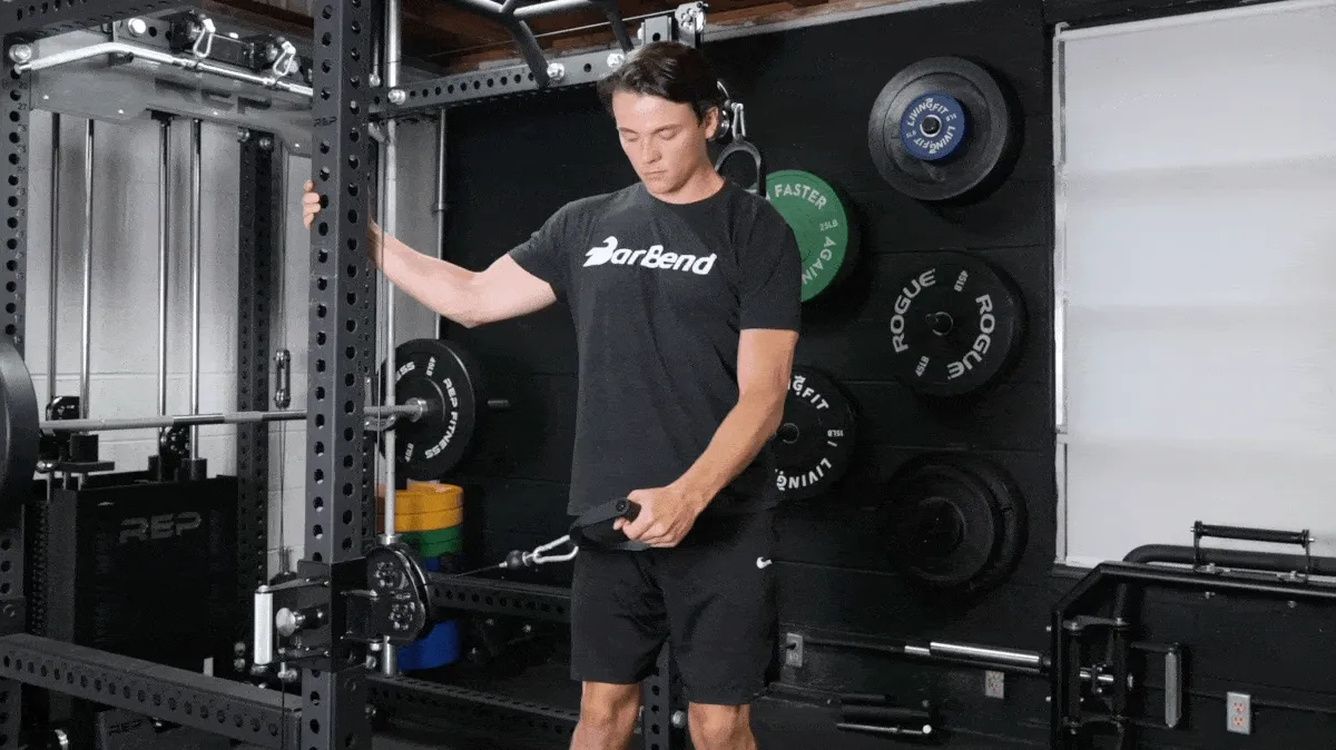 BarBend's Jake Herod performing the cable lateral raise exercise.
