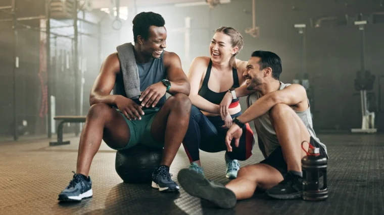 Three people talk after a group workout