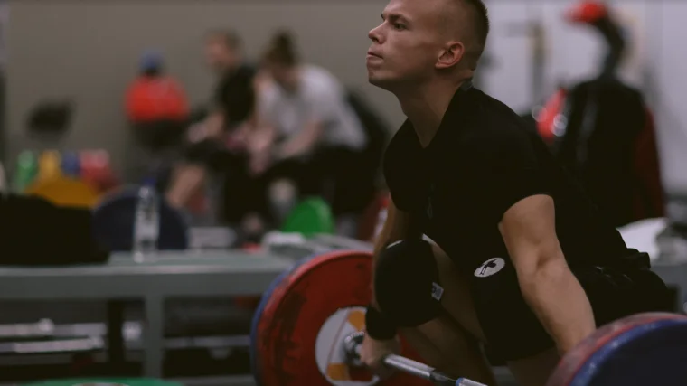 Weightlifter Ritvars Suharevs prepares for hang snatch in training hall 