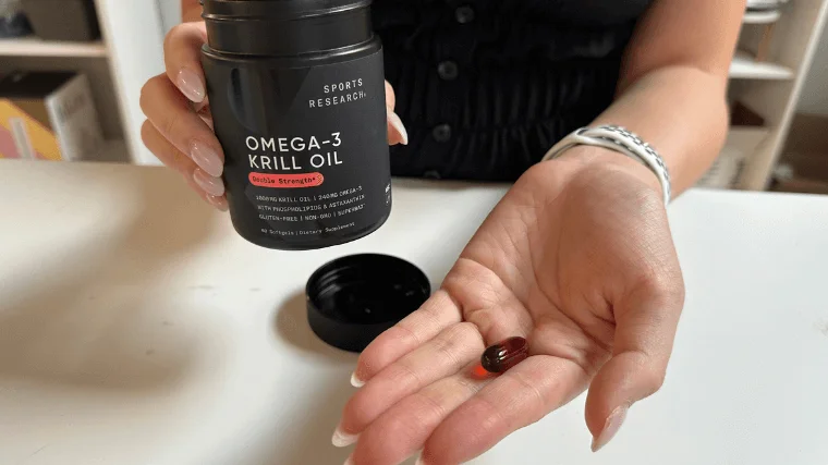 sports research krill oil tester holds in palm of hand