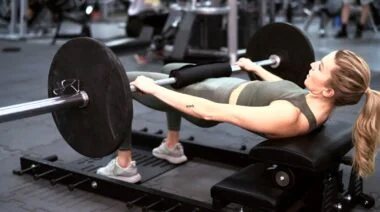A person doing a barbell hip thrust.