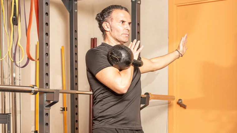 A person performs a kettlebell clean.