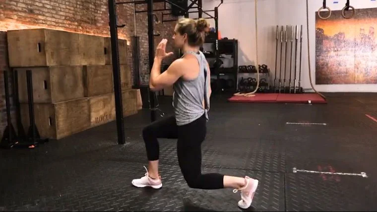 A person wearing cross trainers doing the split squat.