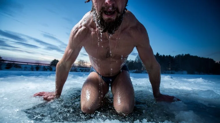 A person submerging in a cold plunge.