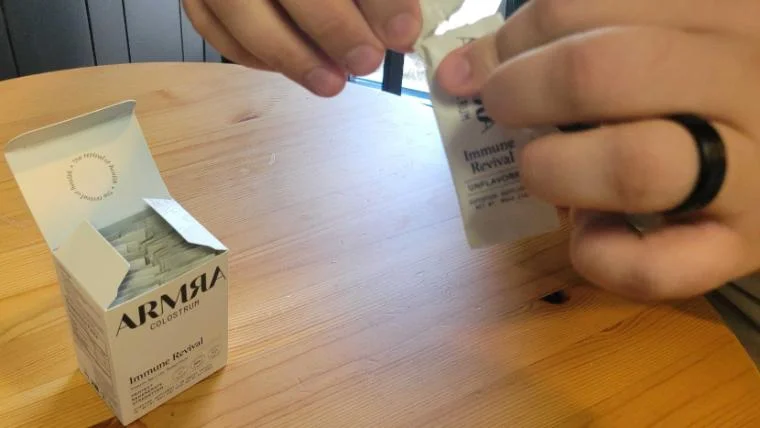 Our tester opening a travel-ready packet of ARMRA Colostrum