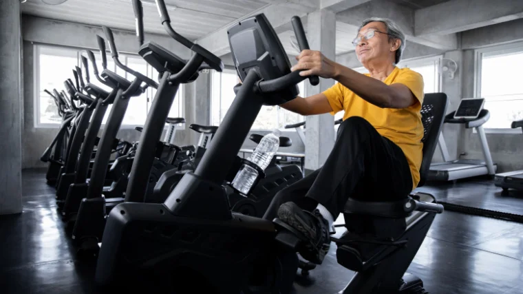 Elderly person on a recumbent bike. 