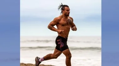 A man runs along the shore at a beach
