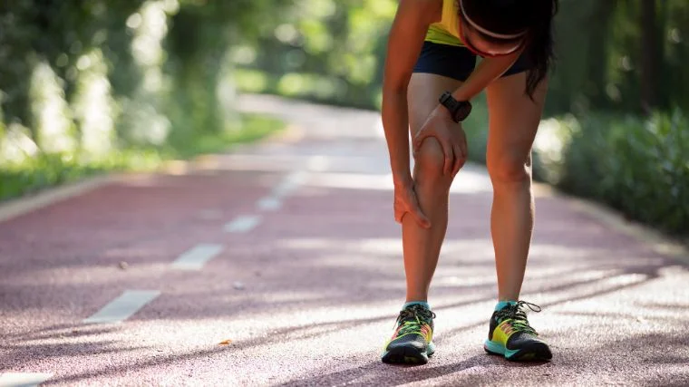 A person stopping from jogging because of pain.