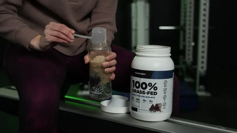Our tester adding a scoop of Transparent Labs Whey Isolate to their shaker cup