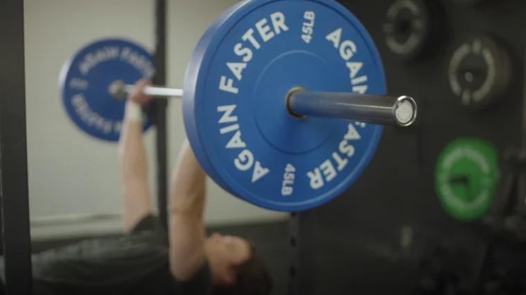 Jake bench pressing with the Again Faster Evo Bumper Plates