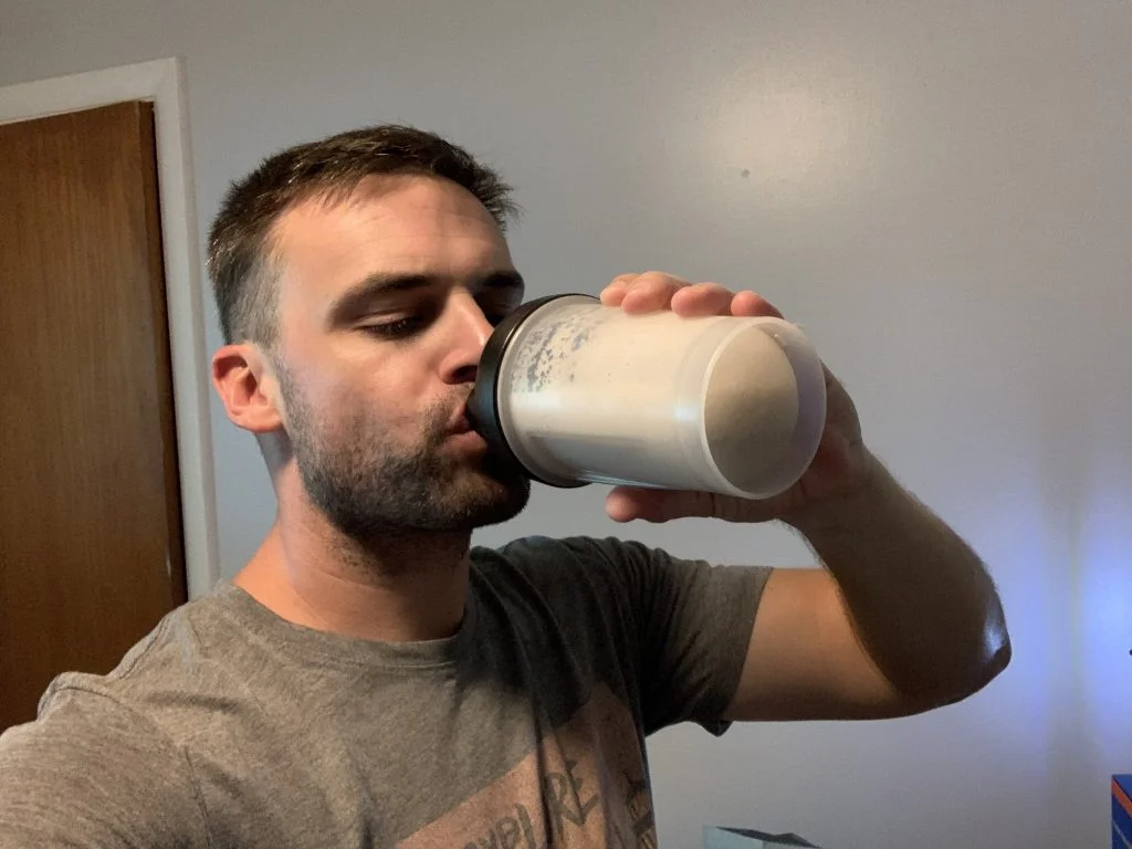 gainful-protein-powder-tester-drinking-front-view A person sipping a Gainful protein powder shake.
