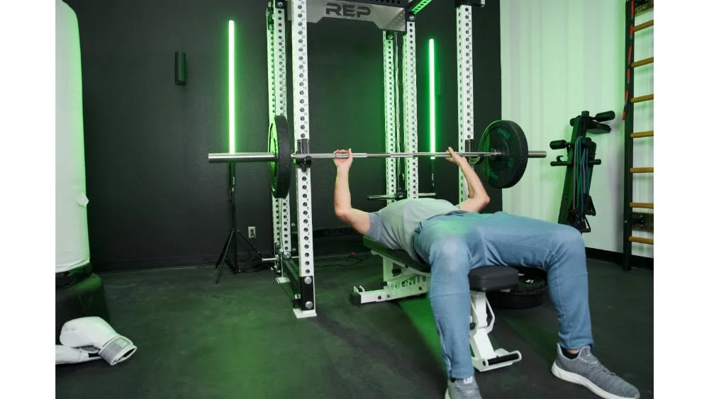 prx-crumb-bumper-plates-unracking-barbell-with-black-and-green-plates prx crumb bumper plates unracking barbell with black and green plates