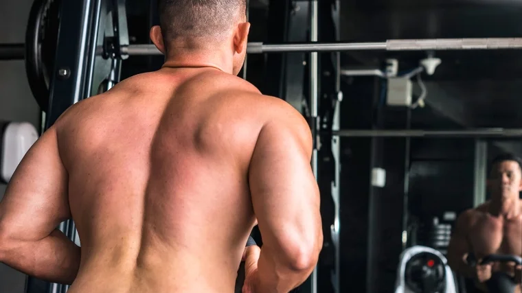 The back of a person doing a kettlebell goblet squat.