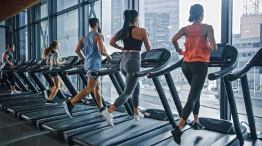 Group of athletic people running on a treadmill.