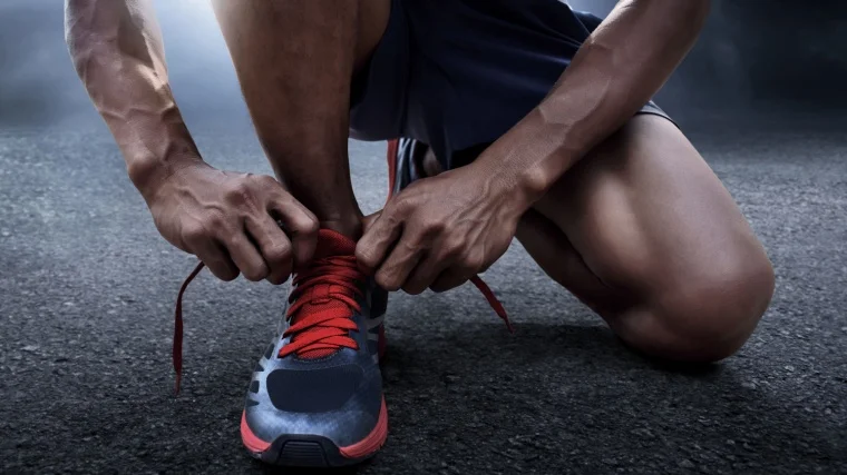 A person fixing their shoelace.