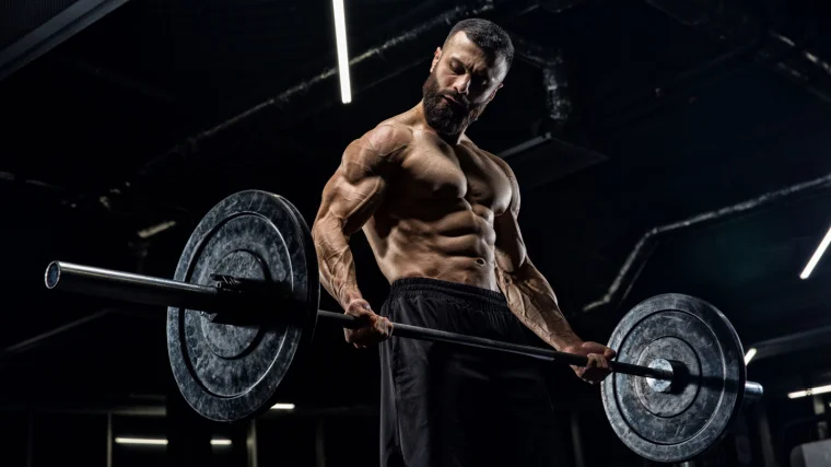 A muscular man lifting a barbell in the gym.