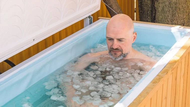 A person submerging in a DIY cold plunge.