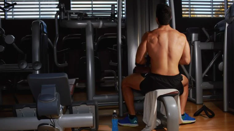 A gymgoer doing neutral-grip pulldowns without arching their back.