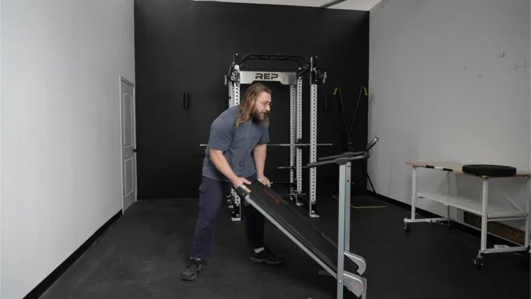 Our tester folding up the Sunny Health and Fitness Manual Treadmill.