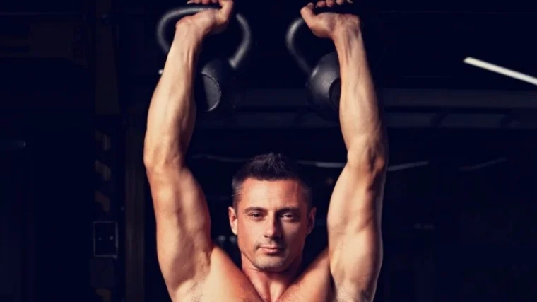 Man pressing kettlebells