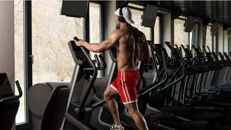 A person doing workout on an elliptical machine in a modern fitness center