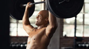 A person pushes through an overhead press.
