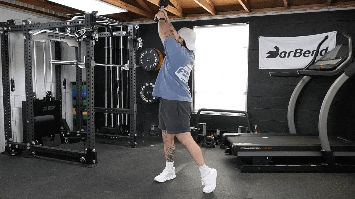BarBend's Jake Herod doing the dumbbell woodchopper exercise, one of the best dumbbell exercises.