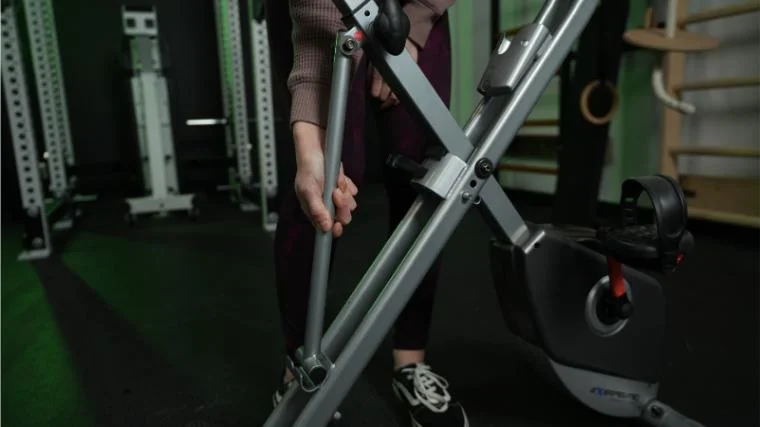 A BarBend product tester unfolding the Exerpeutic 400XL exercise bike.