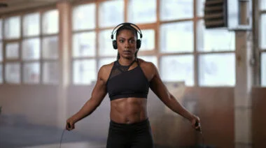 A person jumps rope in the gym while wearing headphones.
