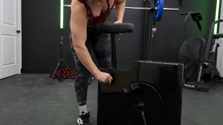 Our tester raising the seat of the Sharper Image Space Saving Stationary Bike