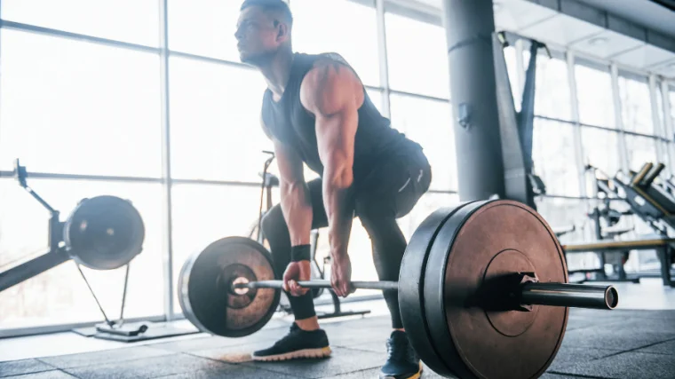 A muscular person deadlifting a barbell.