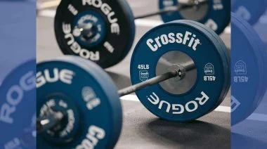 A picture of CrossFit-labeled barbells on the floor of a gym.