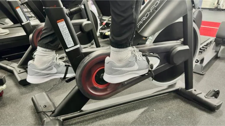 pro-form-studio-bike-pro-22-feet-in-pedals BarBend reviews writer Matt Cummings’ feet strapped into the pedals on the ProForm Studio Bike Pro 22.