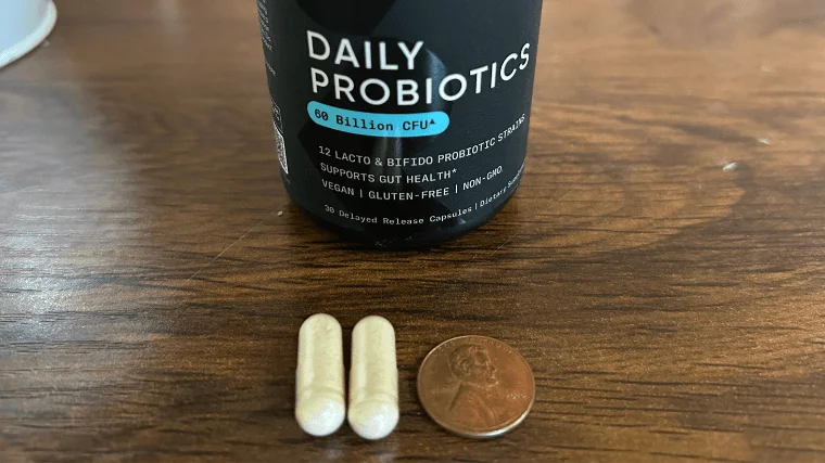 sports research probiotic pill size next to penny