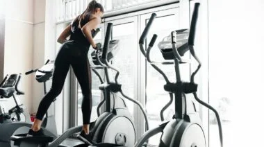 A person on the elliptical machine in the gym.