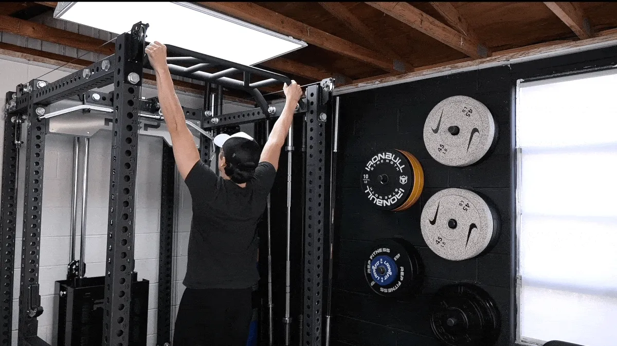A person performing the wide grip pull-up exercise.