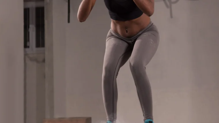 A close-up image shows a person's legs and torso as they land in a box jump.