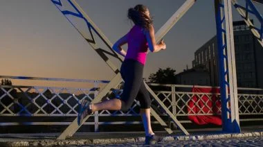 A person in sportswear running in the morning while it is still dark.