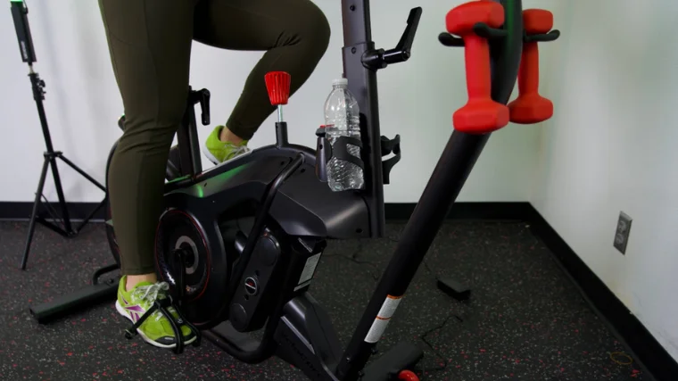 Dumbells held in a cradle on the front of a BowFlex VeloCore Bike.